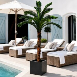 Konstgjord Cycas-palm i svart fyrkantig kruka placerad i exklusiv poolmiljö med loungemöbler.