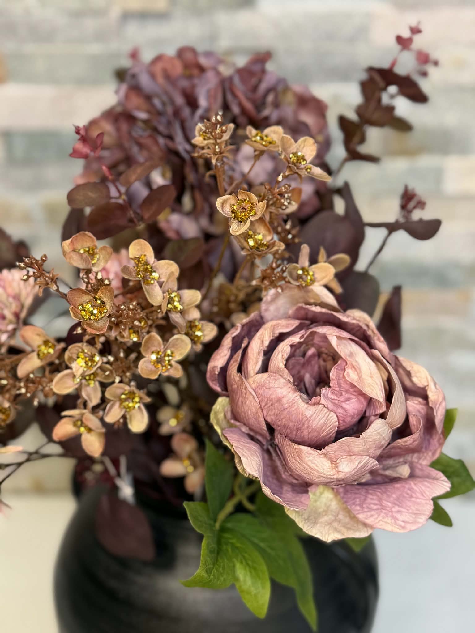 Närbild på rosa blomsterarrangemang med hortensia och dekorativa blommor