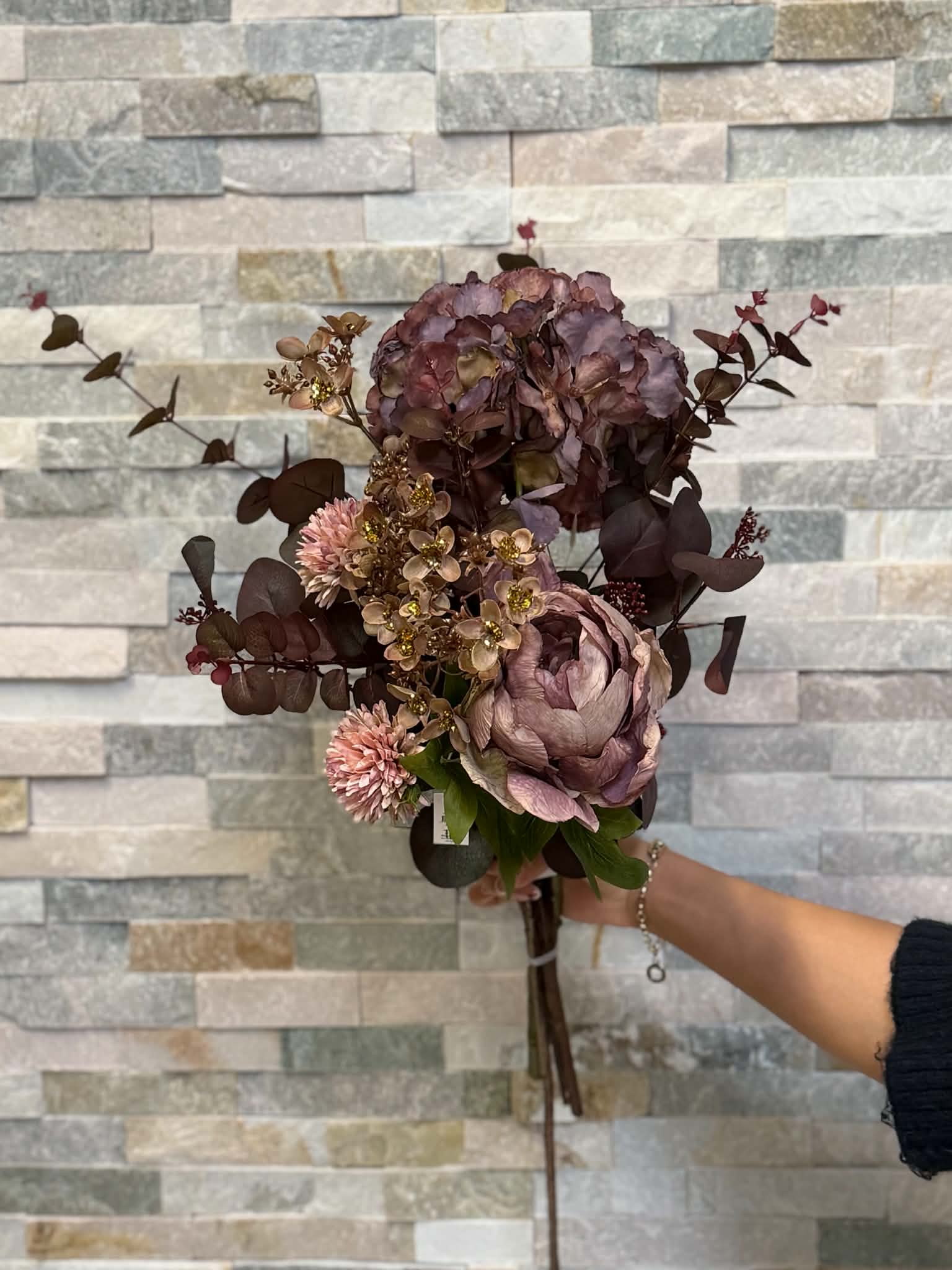 Handbunden bukett med hortensia och rosa blommor i vinröda toner