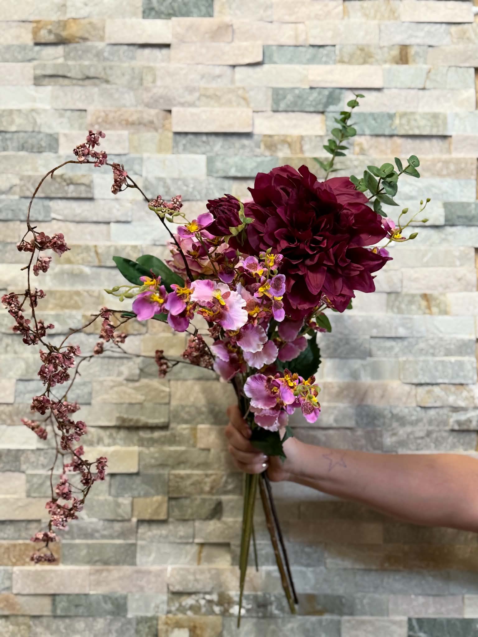 Bukett med mörkröda och lila blommor
