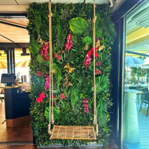 Exklusiv tropisk växtvägg med lila rosa orkidéer och palmblad