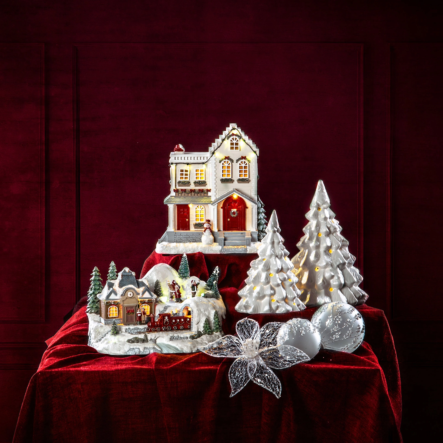 Juldekoration med Frosty julkulor, julhus och snötäckt gran