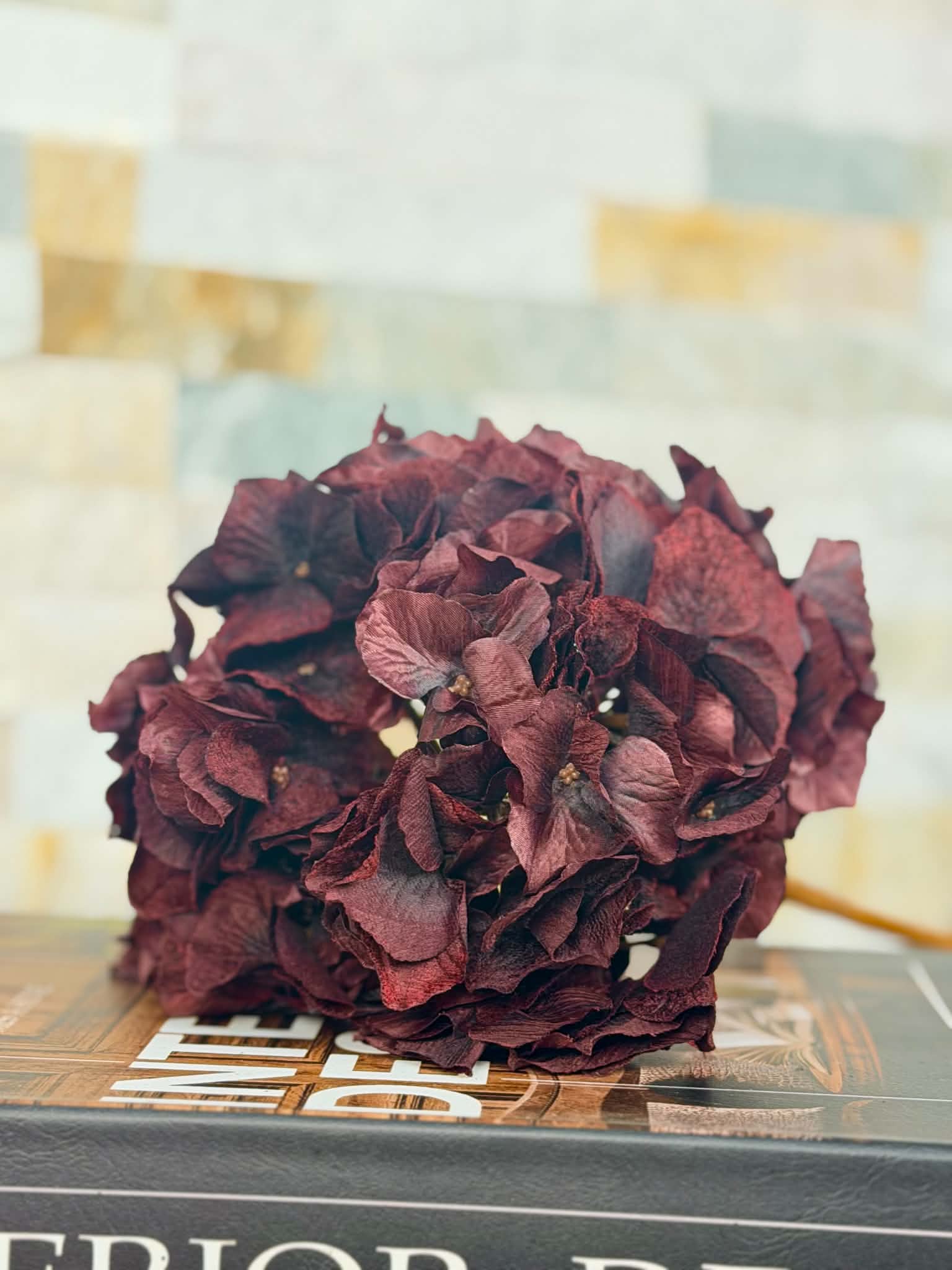 Närbild på konstgjord hortensia bordo 70 cm med fylliga, mörkt vinröda blomblad i ett dekorativt arrangemang.