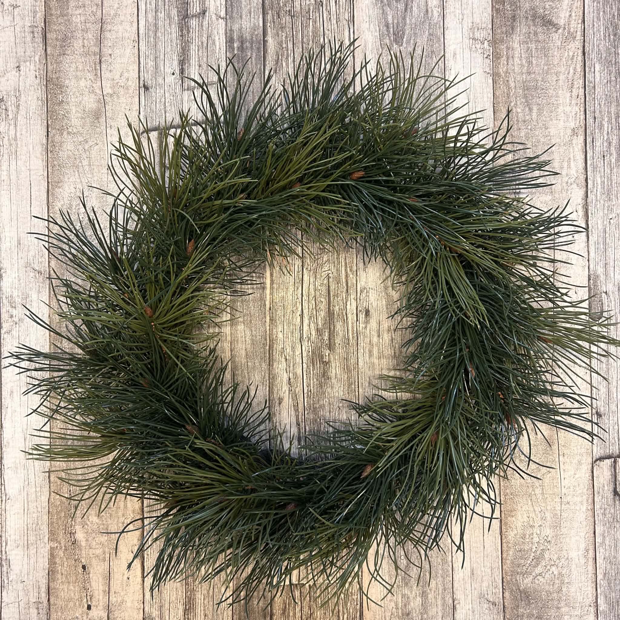 Konstgjord tallkrans 60 cm med gröna tallkvistar och dekorativa knoppar för jul- och vinterdekoration.